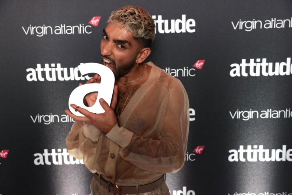 Mawaan Rizwan in a mesh shirt holding his Attitude Award