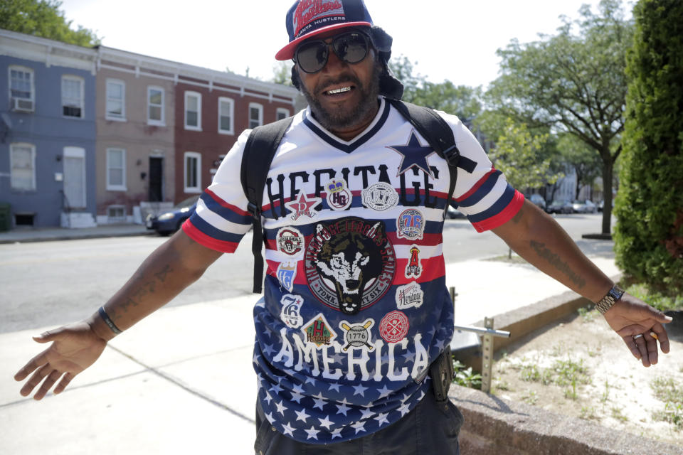 Victor Toulson, 50, displays his patriotic shirt outside of the Sandtown-Winchester Senior Center, Monday, July 29, 2019, in the Sandtown section of Baltimore. Toulson told The Associated Press he was not happy with President Donald Trump's twitter comments over the weekend. In the latest rhetorical shot at lawmakers of color, President Donald Trump vilified Rep. Elijah Cummings majority-black Baltimore district as a "disgusting, rat and rodent infested mess" where "no human being would want to live." (AP Photo/Julio Cortez)