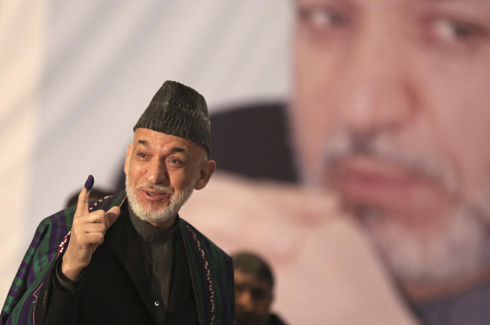 Afghan President Hamid Karzai shows indelible ink on his finger to the media before he casts his vote at Amani High School, near the presidential palace in Kabul, Afghanistan, Saturday, April 5, 2014. Afghan voters lined up for blocks at polling stations nationwide on Saturday, defying a threat of violence by the Taliban to cast ballots in what promises to be the nation's first democratic transfer of power. (AP Photo/Massoud Hossaini)