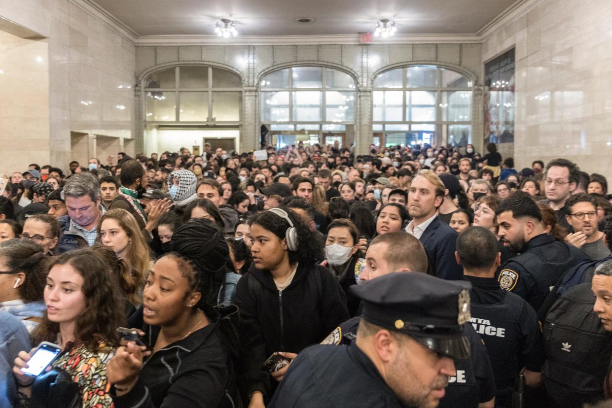 Commuters move through protesters and New York Police Department officers at Grand Central Terminal during a rally calling for a ceasefire between Israel and Hamas on Friday, Oct. 27, 2023, in New York. (AP Photo/Jeenah Moon)