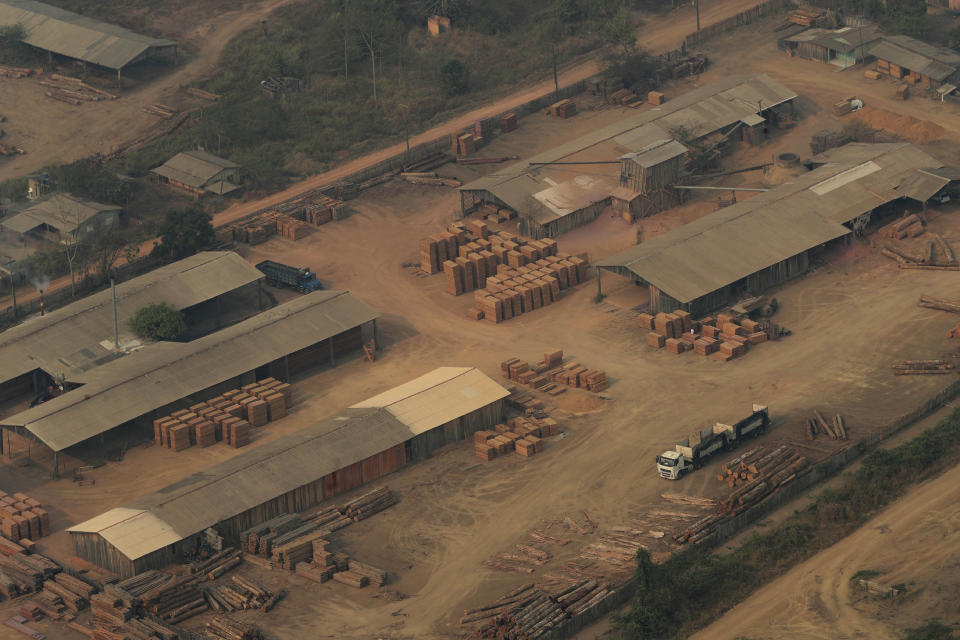 A lumber yard is seen from the air, in the city of Jaci Parana, Rondonia state, Brazil, Saturday, Aug. 24, 2019. Brazil says military aircraft and 44,000 troops will be available to fight fires sweeping through parts of the Amazon region. The defense and environment ministers have outlined plans to battle the blazes that have prompted an international outcry as well as demonstrations in Brazil against President Jair Bolsonaro's handling of the environmental crisis. (AP Photo/Eraldo Peres)