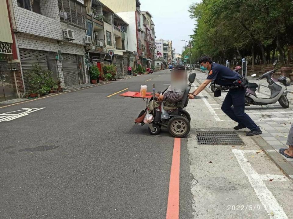 金華所警方接獲陳男求救隨即趕往現場救援，連同輪椅將陳推至附近商家休息充電。(讀者提供)