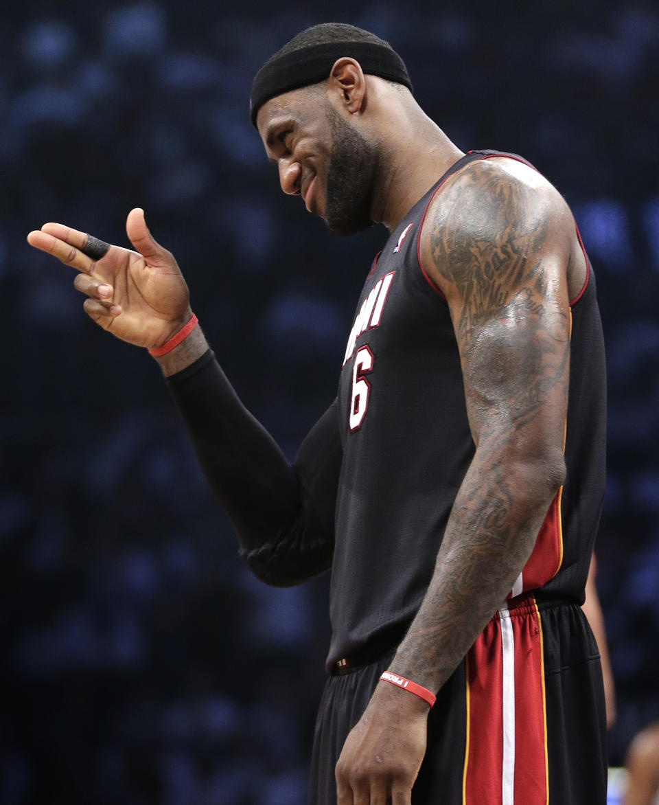 Miami Heat forward LeBron James (6) motions to a fan during a break in play against the Brooklyn Nets in the second period of Game 3 of an Eastern Conference semifinal NBA playoff basketball game on Saturday, May 10, 2014, in New York. (AP Photo/Julie Jacobson)