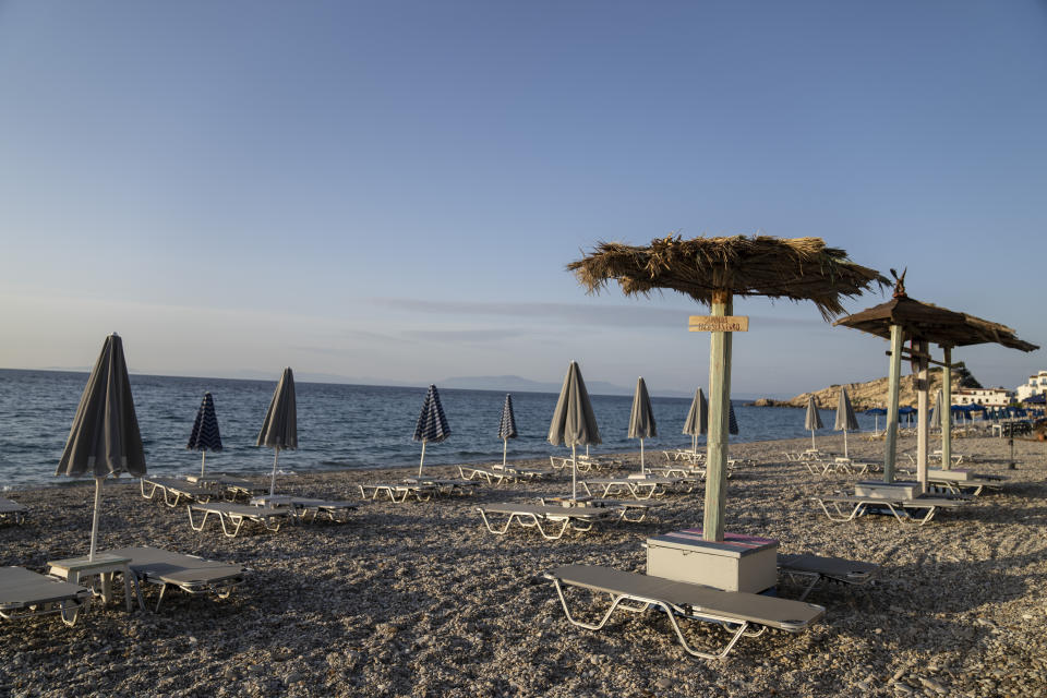 Empty sunbeds stand seaside village of Kokkari on the Greek island of Samos, on Tuesday, June 8, 2021. About a month after Greece officially opened to international visitors, the uncertainty of travel during a pandemic is still taking its toll on the country's vital tourist industry. (AP Photo/Petros Giannakouris)