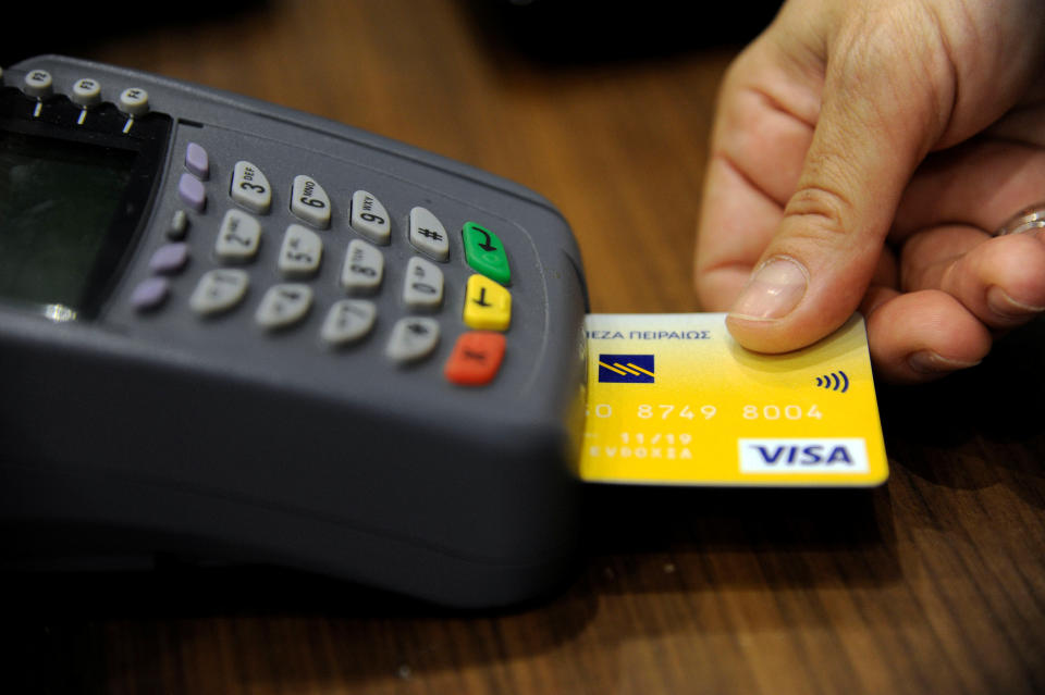 A sales staff accepts payment by credit card through a point-of-sale (POS) device at a boutique shop in central Athens, Greece, May 10, 2016. Picture taken May 10, 2016. REUTERS/Michalis Karagiannis