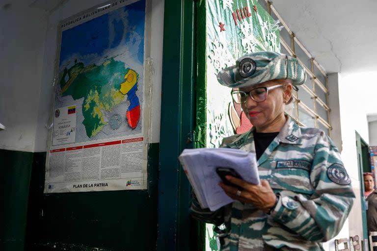 Un miembro de las Milicias Bolivarianas toma notas en un colegio electoral durante el referéndum consultivo sobre la soberanía venezolana sobre la región del Esequibo controlada por la vecina Guyana, en Caracas el 3 de diciembre de 2023.