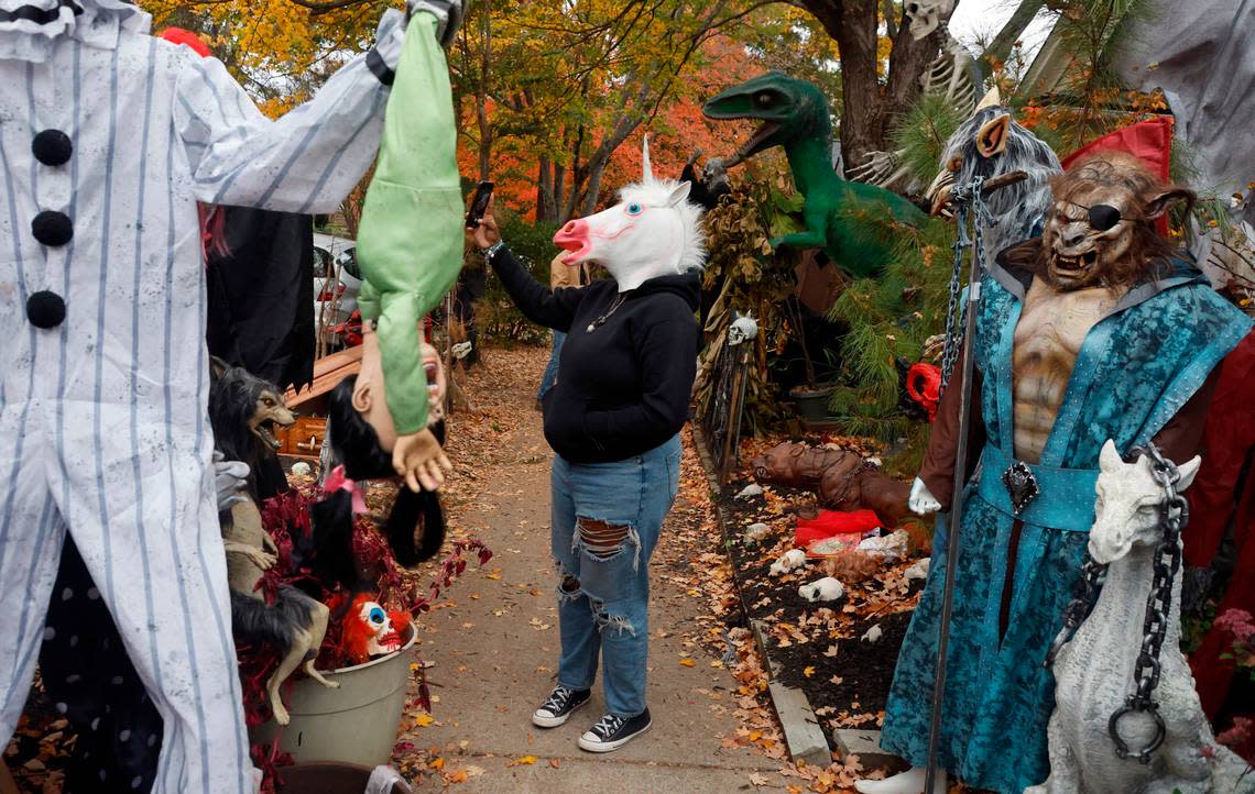 Arielle Jackson takes her photo outside the Oakwood home of Jesse Jones Friday, Oct. 28, 2022. More than 50 full-sized monsters are set up in Jones’ yard bringing thousands of visitors on Halloween.