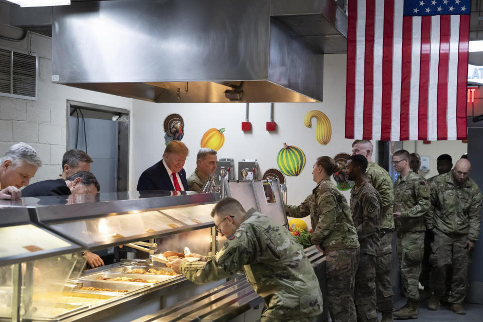 President Donald Trump accompanied by Joint Chiefs Chairman Gen. Mark Milley, right, serves dinner during a surprise Thanksgiving Day visit to the troops, Thursday, Nov. 28, 2019, at Bagram Air Field, Afghanistan. (AP Photo/Alex Brandon)