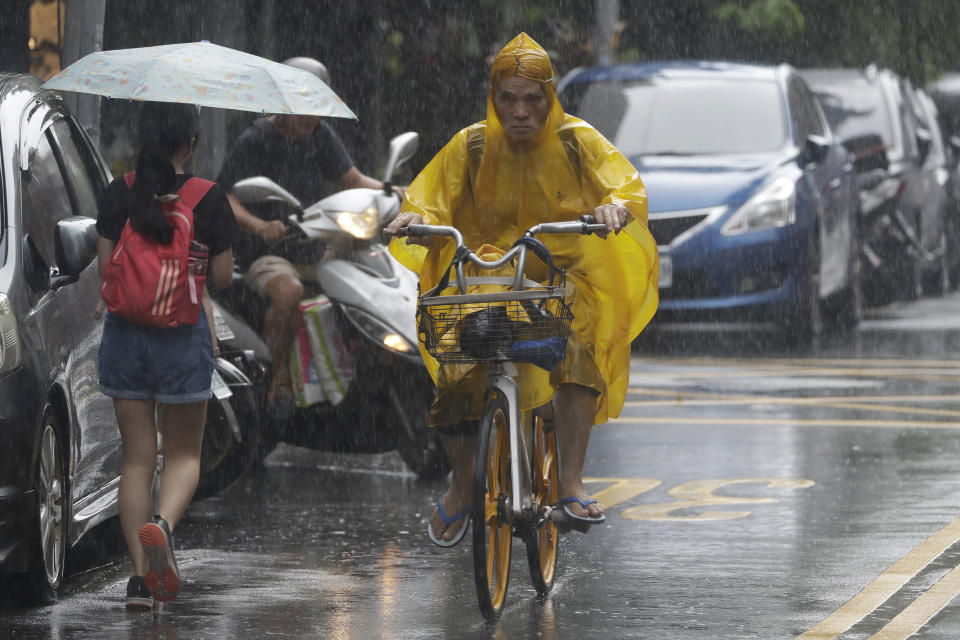 People make their ways in a rain ahead of the approaching Typhoon Hinnamnor in Taipei, Taiwan, Saturday, Sept. 3, 2022. (AP Photo/Chiang Ying-ying)