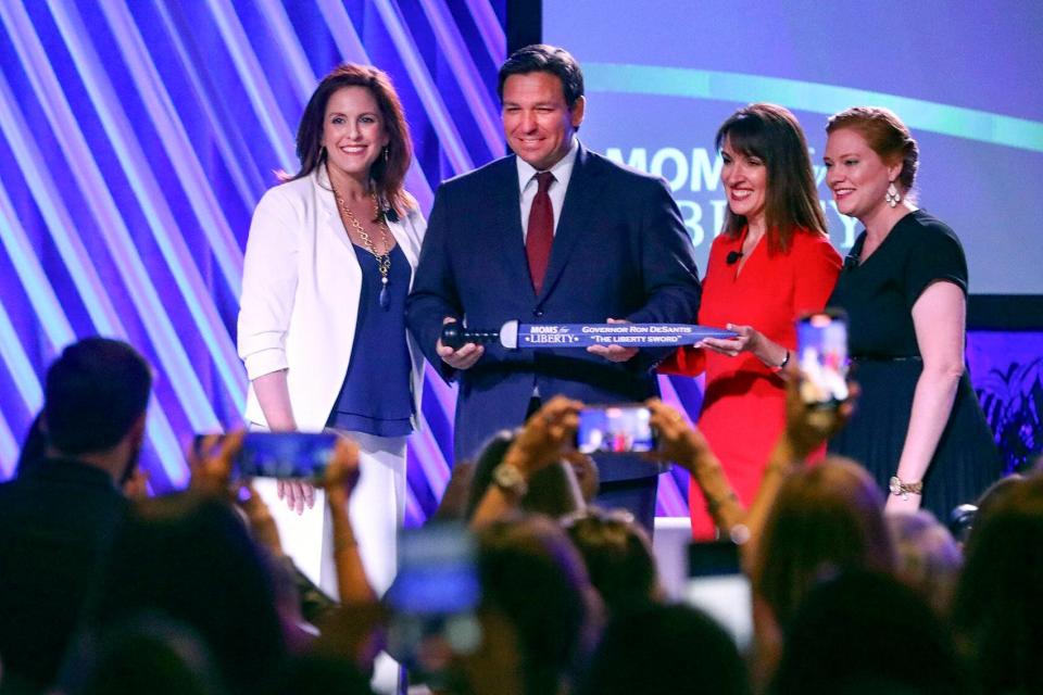 Florida Gov. Ron DeSantis is presented with "The Liberty Sword" during the Moms for Liberty National Summit in Tampa in July 2022.