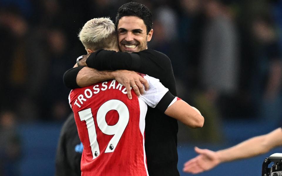 Arsenal's Belgian midfielder #19 Leandro Trossard is embraced by Arsenal's Spanish manager Mikel Arteta