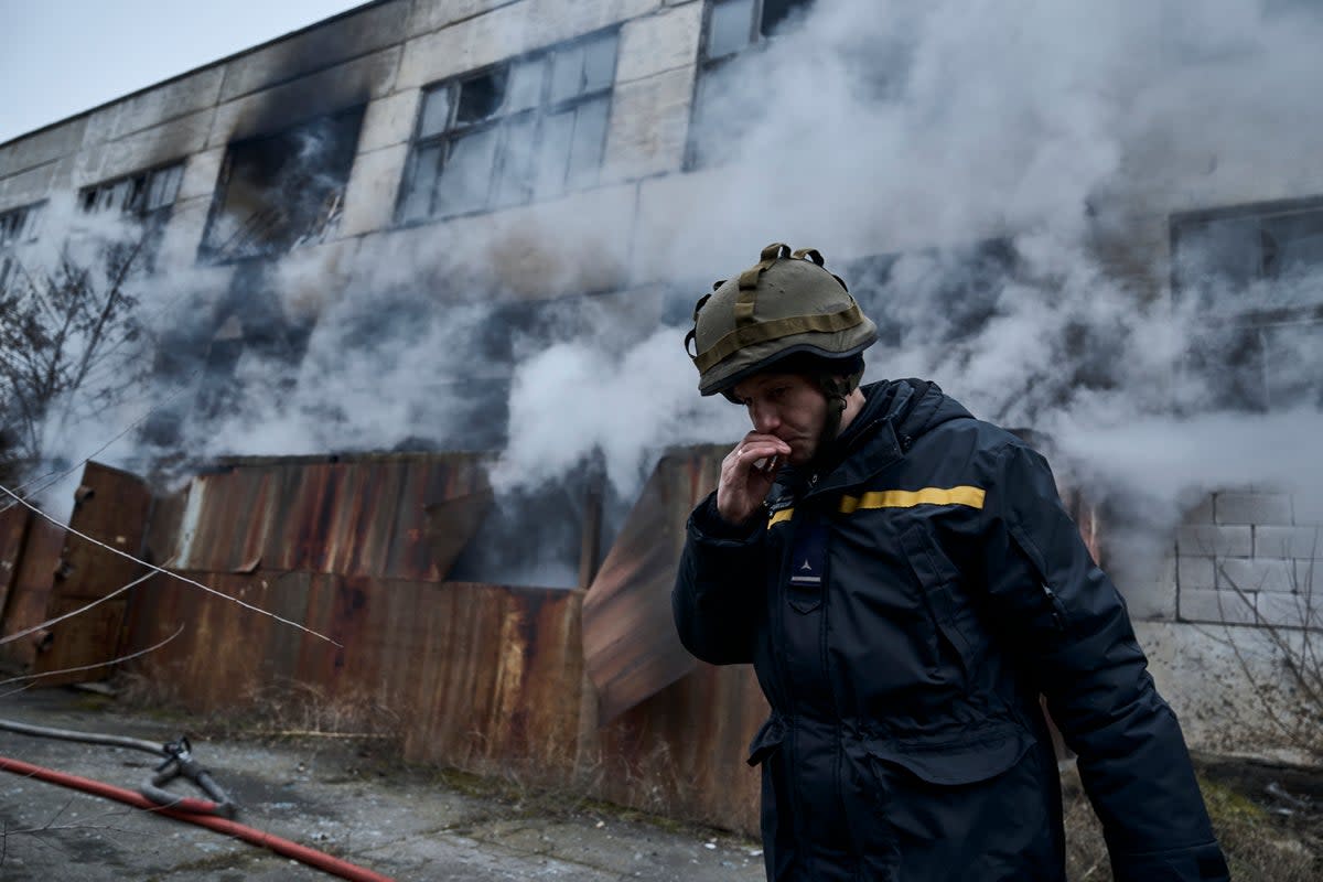 A Ukrainian State Emergency Service firefighter smokes as he takes a break following Russian shelling that hit an industrial area in Kherson  (AP)