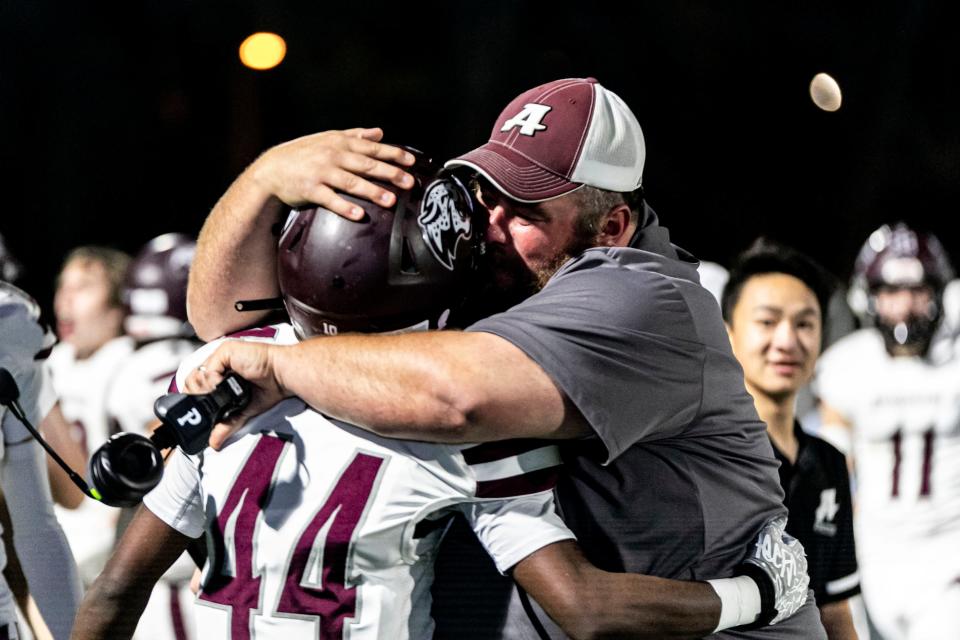 Appoquinimink coach Brian Timpson celebrates with Haji Bell (44) near the end of the Jaguars' 30-20 victory over Salesianum at Abessinio Stadium on Saturday night.