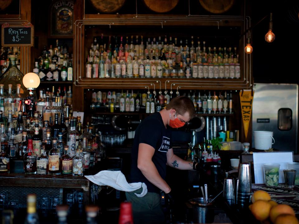 A bartender wearing a facemask and gloves makes drinks at Eight Row Flint in Houston, Texas, on May 22, 2020, amid the novel coronavirus pandemic.