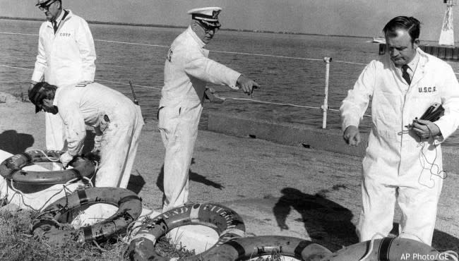 In a Nov. 24, 1975 photo, Coast Guard officers on a Board of Inquiry inspected life rings that were recovered from the ore carrier Edmund Fitzgerald, which sank in stormy weather in Lake Superior on Nov. 10, 1975. (AP Photo/GE)