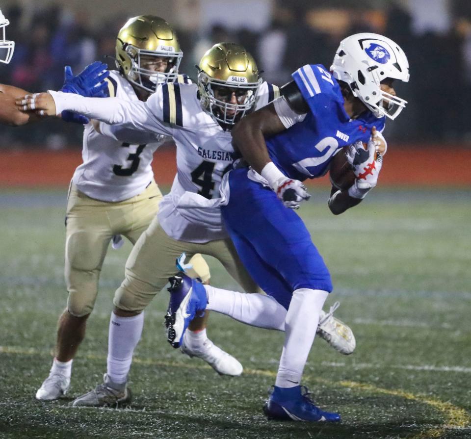 Salesianum's John Casale (center) tries to wrap up Dover's Jakwon Kilby (right) as Salesianum's Nicholas Strusowski moves in during the fourth quarter of the Senators' 27-16 win in Dover, Friday, Sept. 29, 2023.