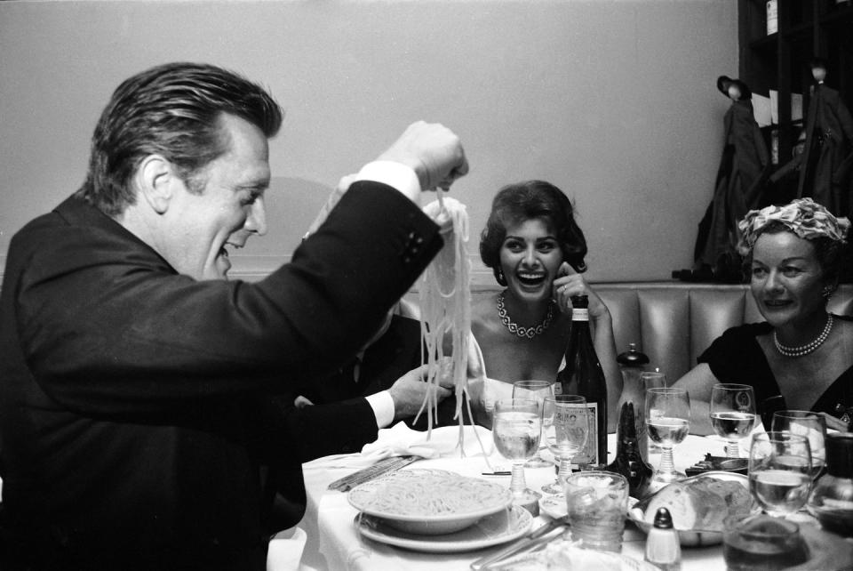 <p>Douglas serves himself a pile of spaghetti as actress Sophia Loren looks on. </p>