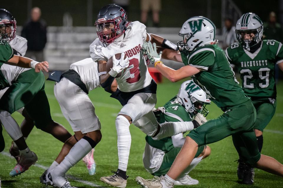 Fitchburg wide receiver  Joshua Medina runs through a pack of Wachusett defenders.