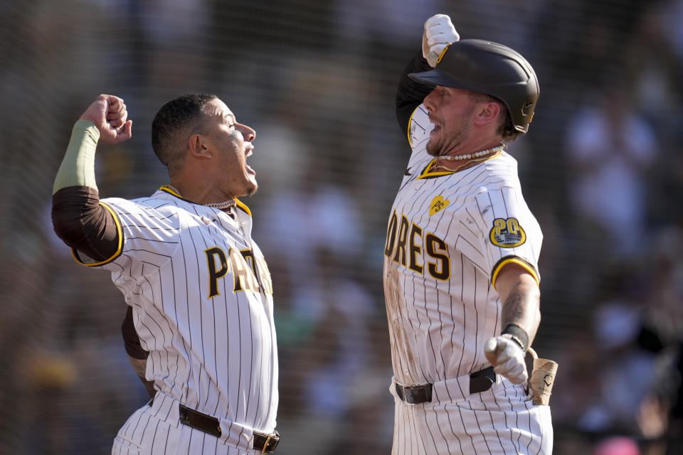 San Diego Padres' Jackson Merrill, right, celebrates with teammate Manny Machado after hitting a three-run home run during the fourth inning of a baseball game against the Milwaukee Brewers, Saturday, June 22, 2024, in San Diego. (AP Photo/Gregory Bull)