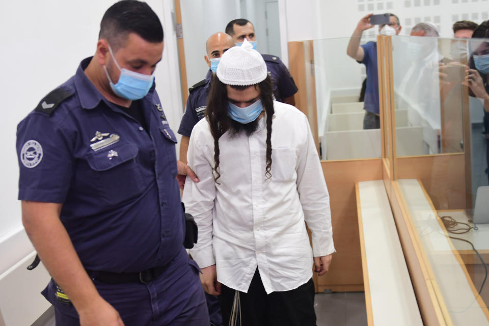 Israeli right-wing activist Amiram Ben-Uliel arrives at a district court for a verdict in the city of Lod, Israel, Monday, May 18, 2020. An Israeli district court has convicted Ben-Uliel of murder in a 2015 arson attack that killed a Palestinian toddler and his parents. (Avshalom Sassoni/Pool Photo via AP)