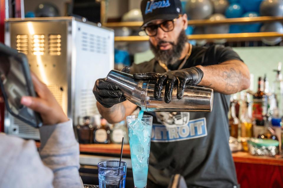 Flood's bartender Raymond Watson pours up a game-day Honolulu blue cocktail inside of Flood's Bar on Sunday, Jan 21, 2024 in Detroit.