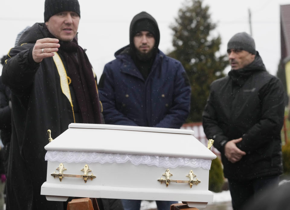 A Polish imam, left, and two other members of a Muslim community bury the tiny white casket of an unborn Iraqi boy, in Bohoniki, Poland, on Tuesday Nov. 23, 2021. The child is the latest life claimed as thousands of migrants from the Middle East have sought to enter the European Union but found their path cut off by a military build-up and fast approaching winter in the forests of Poland and Belarus. (AP Photo/Czarek Sokolowski)