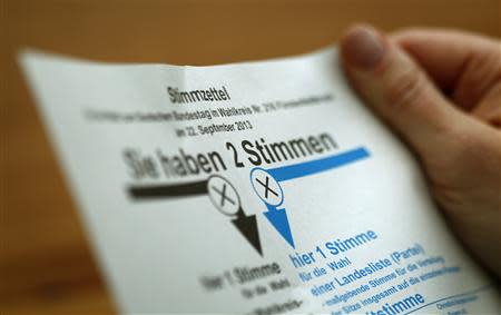Woman holds a postal voting ballot paper for the upcoming German general election in Munich September 11, 2013. REUTERS/Michaela Rehle