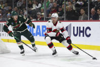 Ottawa Senators defenseman Jake Sanderson, right, skates with the puck alongside Minnesota Wild left wing Kirill Kaprizov during the first period of an NHL hockey game Tuesday, April 2, 2024, in St. Paul, Minn. (AP Photo/Matt Krohn)