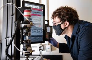 NREL researcher Nic Rorrer tests a sample of a new plastic formulation for its tensile properties. As part of Gregg Beckham's plastics research group, Rorrer is working on the redesign of nylon (aka polyamide) polymers so they can be chemically recycled with more efficient and less energy-intensive processes. Photo by Dennis Schroeder, NREL