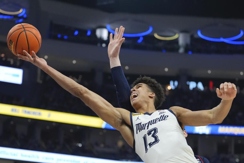 Marquette's Oso Ighodaro shoots past UConn's Donovan Clingan during the first half of an NCAA college basketball game Wednesday, March 6, 2024, in Milwaukee. (AP Photo/Morry Gash)