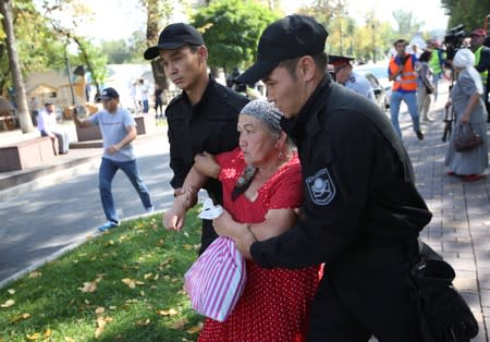 Law enforcement officers detain a woman during an anti-government protest in Almaty