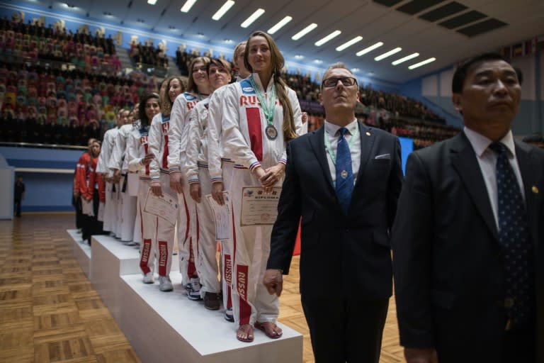 In a photo taken on September 21, 2017 team members from North Korea (C) and Russia (R) stand on the podium of during the medal ceremony of womens team event of the 20th ITF World Taekwondo Championships in Pyongyang