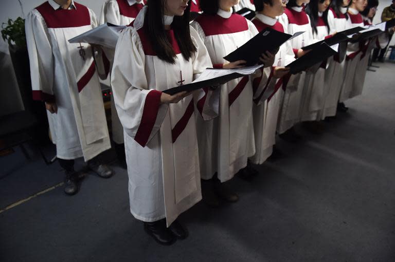 A choir of an underground church sings at a Christmas Eve service at an apartment in Beijing on December 24, 2014