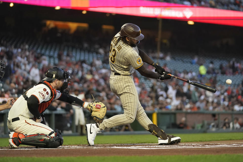 San Diego Padres' Fernando Tatis Jr. (23) hits a double in front of San Francisco Giants catcher Patrick Bailey during the first inning of a baseball game in San Francisco, Monday, Sept. 25, 2023. (AP Photo/Jeff Chiu)