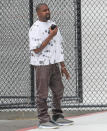 <p>Kanye West grabs a call on Wednesday while at the Van Nuys Airport in Los Angeles. </p>