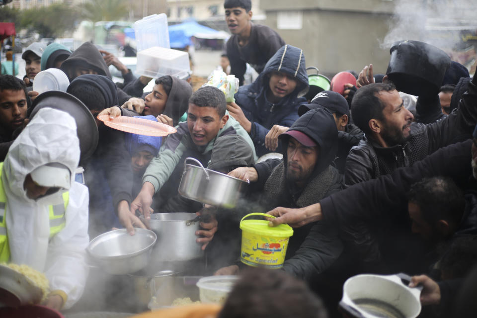 Palestinians line up for free food distribution during the ongoing Israeli air and ground offensive in Khan Younis, Gaza Strip, Friday, Feb. 2, 2024. (AP Photo/Hatem Ali)