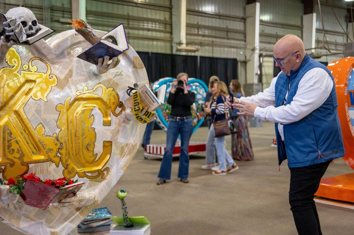 Jeff Rogers takes a photo of the heart titled “Once Upon a City” by artist Dani Romay and Laura King Friday during the Parade of Hearts reveal kickoff event.