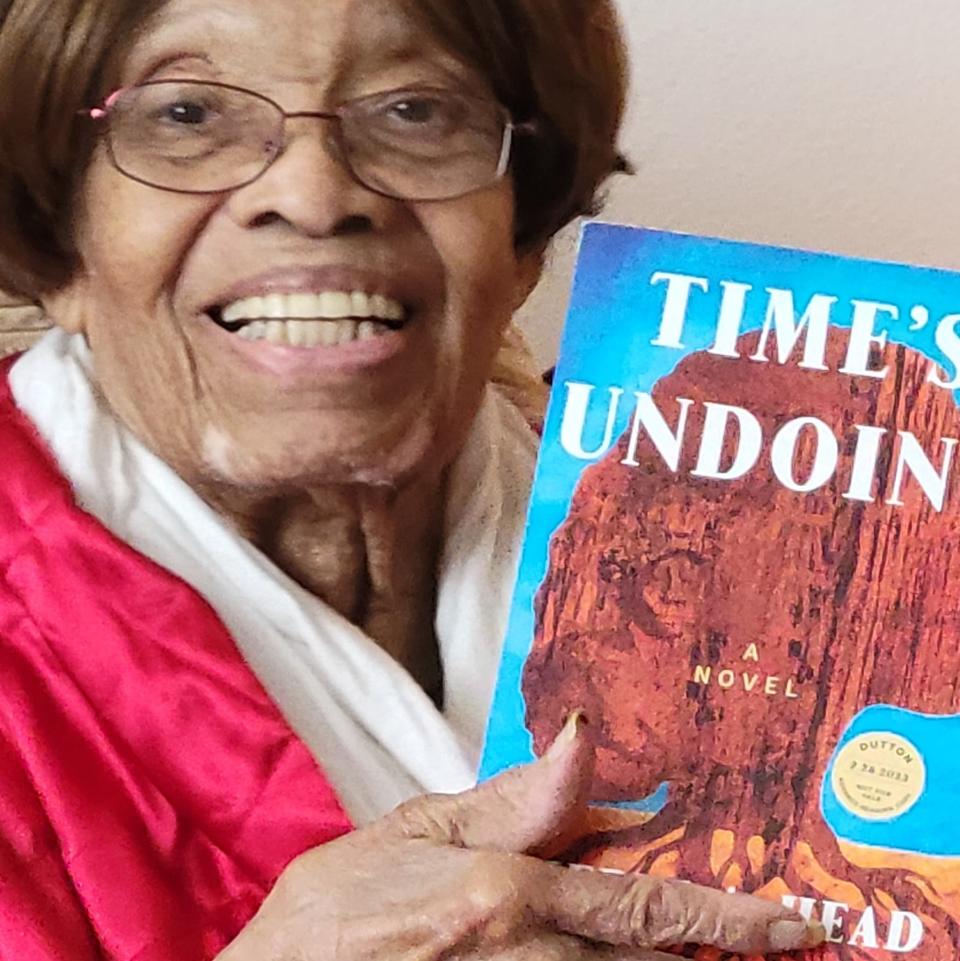 Willie Mae McGarrah holding a copy of her daughter Cheryl A. Head's novel "Time Undoing," which tells a fictionalized version of McGarrah's father's life.