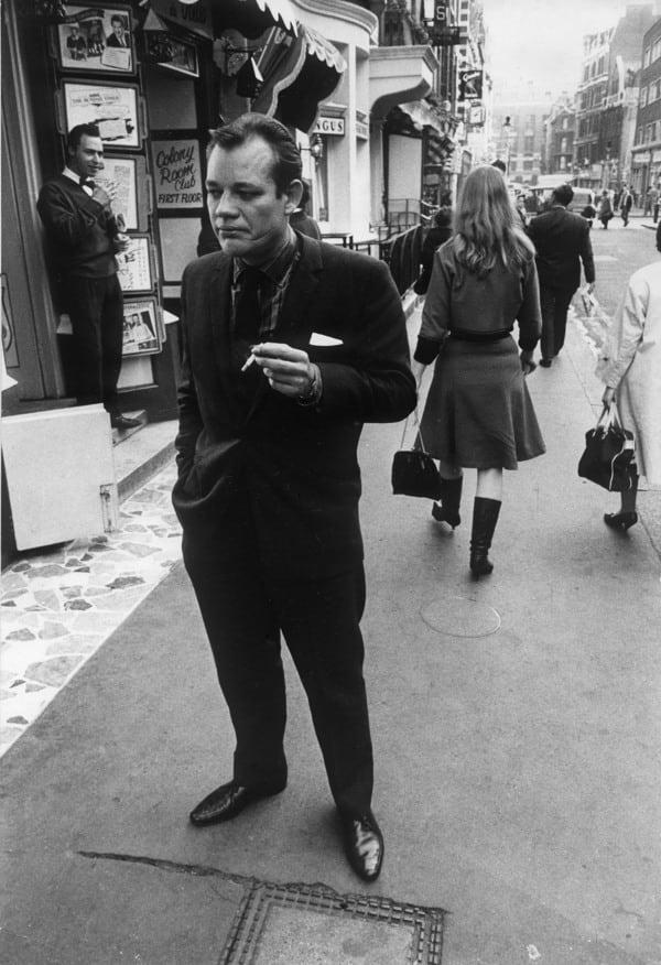 <div class="inline-image__caption"><p>Writer Frank Norman outside the Colony Room in London’s Soho</p></div> <div class="inline-image__credit">Daniel Farson / Tales from The Colony Room</div>