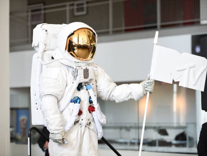 An astronaut holding up an MTV flag