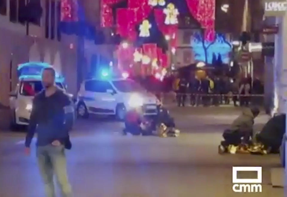 In this image made from video provided by CMM, people lay on the ground after a shooting at a Christmas market in Strasbourg, France, Tuesday, Dec. 11, 2018. A French regional official says that a shooting in Strasbourg has left at least one dead and several wounded in the city center near a world-famous Christmas market. The prefect of France's Bas-Rhin region says the gunman, who is still at large, has been identified. Authorities haven't given a motive for the shooting. (CMM via AP)