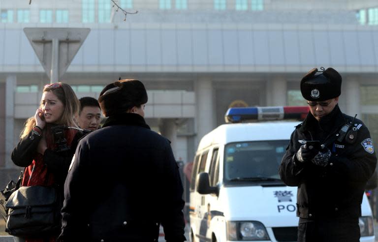 Chinese police stop a foreign journalist (L) outside the No. 1 Intermediate court in Beijing on January 22, 2014, as strict security was imposed ahead of the trial of Xu Zhiyong, one of China's most prominent dissidents