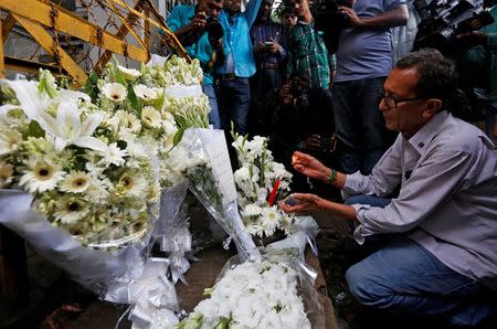 A man lights a candle at a makeshift memorial, to pay tribute to the victims of the attack on the Holey Artisan Bakery and the O'Kitchen Restaurant, near the site of the attack in Dhaka, Bangladesh, July 3, 2016. REUTERS/Adnan Abidi