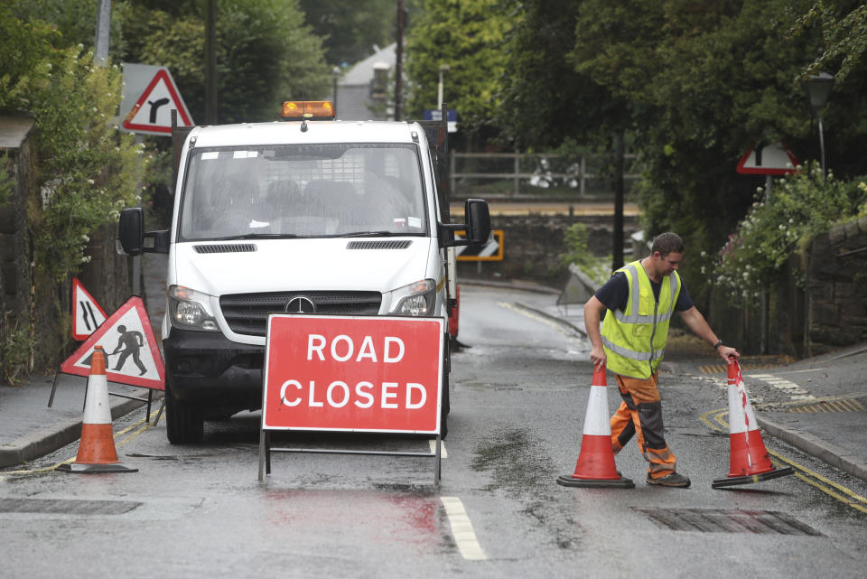 A roadblock is put in place at Whaley Lane the entrance to the village of Whaley Bridge, Cheshire, England, Thursday, Aug. 1, 2019. British police have ordered the evacuation of a town of 6,500 residents in northwest England over fears that a dam could collapse. The Derbyshire Police force says residents of Whaley Bridge should leave their homes because of the "significant threat to life." (Danny Lawson/PA via AP)