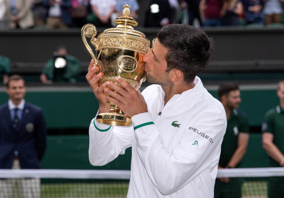 Tennis - Wimbledon - All England Lawn Tennis and Croquet Club, London, Britain - July 11, 2021   Serbia's Novak Djokovic kisses the trophy as he celebrates after winning his final match against Italy's Matteo Berrettini Pool via REUTERS/Ben Solomon