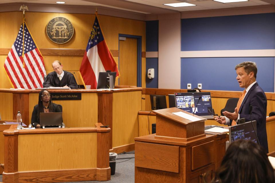 Brian Rafferty, right, attorney for Sidney Powell, addresses the court during a motions hearing in front of Fulton County Superior Court Judge Scott McAfee, top left, in Atlanta, Thursday, Oct. 5, 2023. Nineteen people, including former President Donald Trump, were indicted in August and accused of participating in a wide-ranging illegal scheme to overturn the results of the 2020 presidential election. (Erik S. Lesser/Pool Photo, via AP)