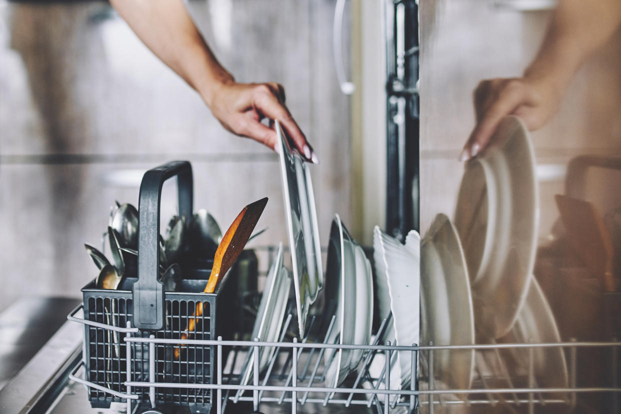 Stock picture of a woman loading a dishwasher incorrectly. (Getty Images)