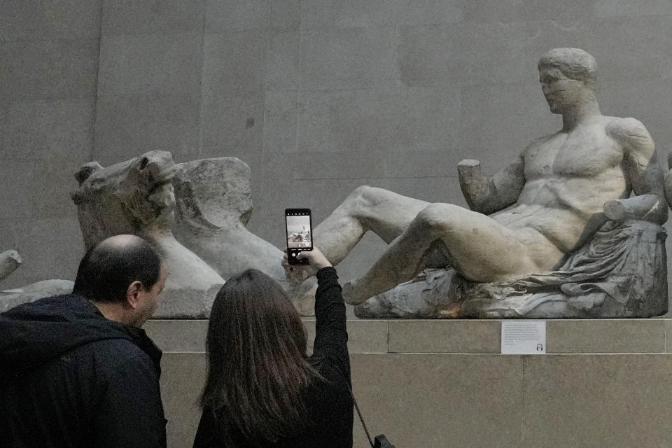A visitor takes a picture of sculptures that are part of the Parthenon Marbles at the British Museum in London, Tuesday, Nov. 28, 2023. Greek officials said Tuesday Nov. 28, 2023 that they will continue talks with the British Museum on bringing the Parthenon Marbles back to Athens, despite U.K. Prime Minister Rishi Sunak cancelling a meeting with his Greek counterpart where the contested antiquities were due to be discussed.(AP Photo/Kirsty Wigglesworth)