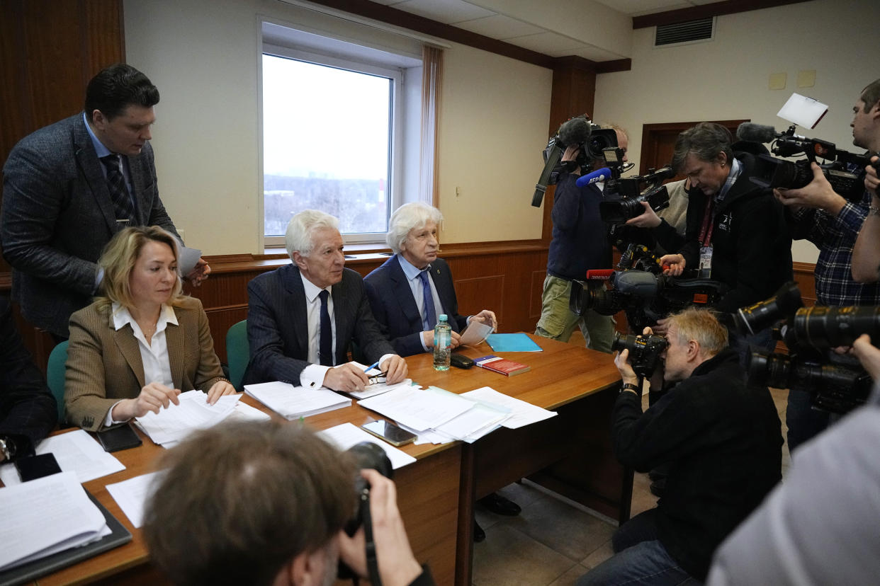 Members of the Moscow Helsinki Group and their lawyers talk with journalists in the courtroom before a hearing on the lawsuit to liquidate the Moscow Helsinki Group in Moscow, Russia, Wednesday, Jan. 25, 2023. The Moscow Helsinki Group is one of the country's oldest human rights organizations. (AP Photo/Alexander Zemlianichenko)