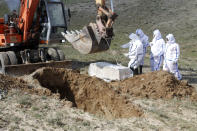 FILE - In this Friday, March 27, 2020 file photo, municipality workers bury the body of coronavirus victim on the outskirts of Herat province west of Kabul, Afghanistan. Across the Middle East and parts of South Asia, bereaved families have faced traumatic restrictions on burying their dead amid the pandemic. Religion and customs that require speedy burials in the largely Muslim region have clashed with fears of COVID-19 contagion and government-mandated lockdowns. (AP Photo/Hamed Sarfarazi, File)